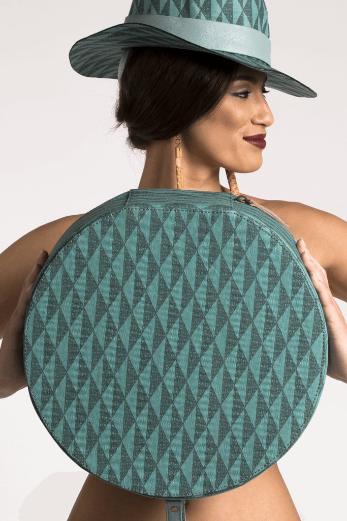 Female Model holding a Manaola Bag in Teal and Green
