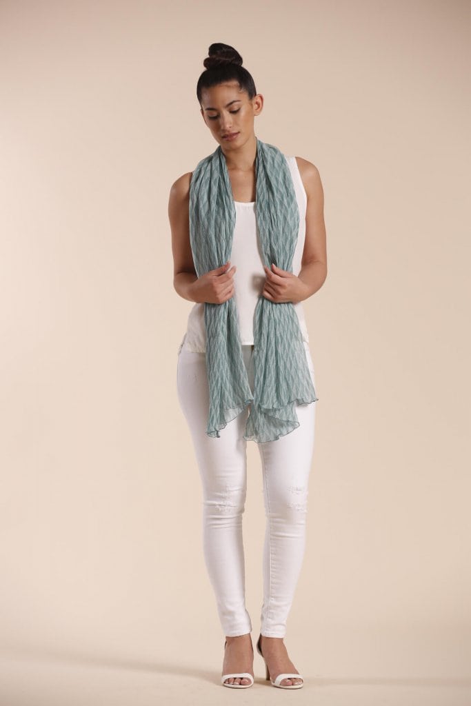 Female model wearing a sage green scarf