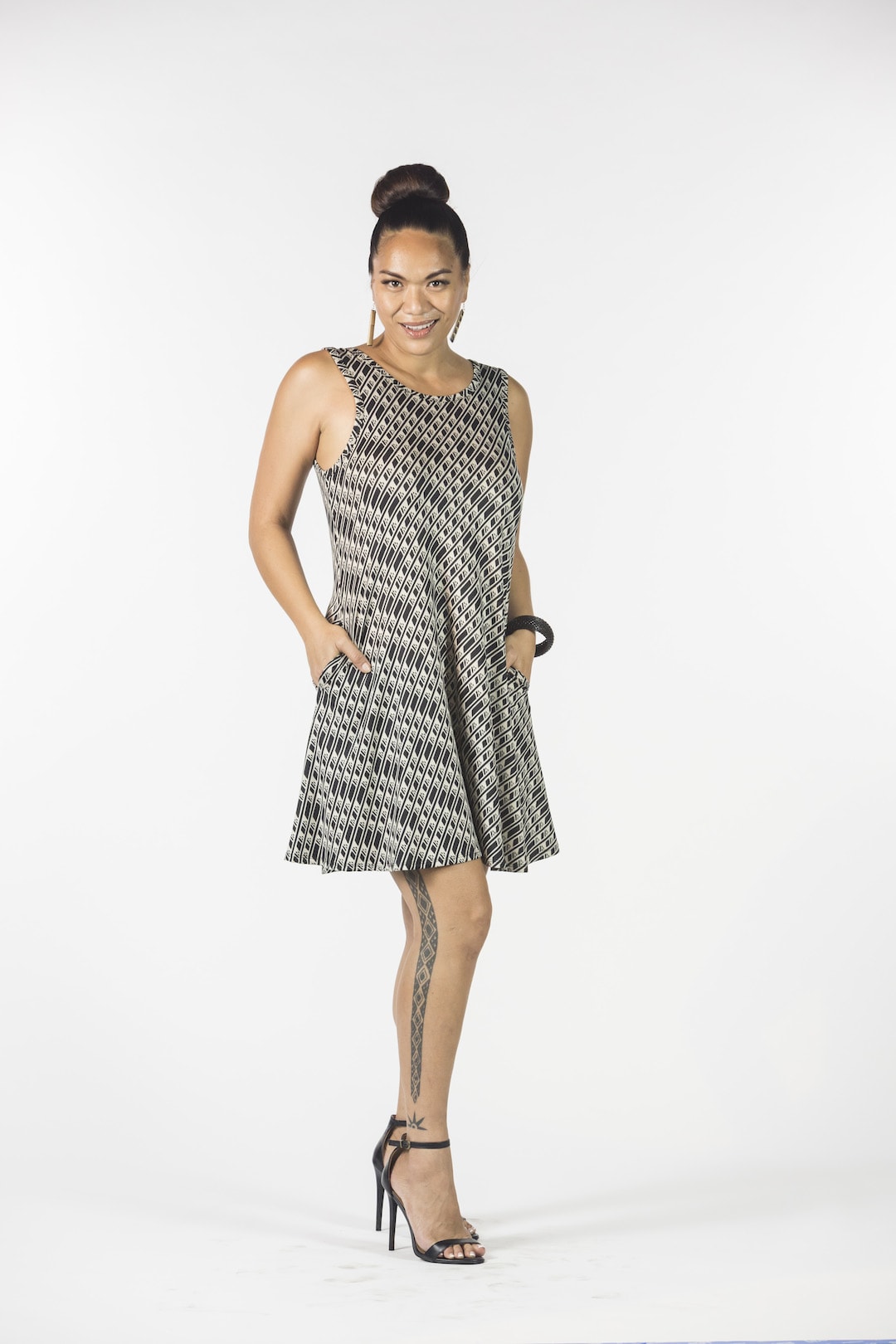 Female model wearing sleeveless dress in Black and White - Front View