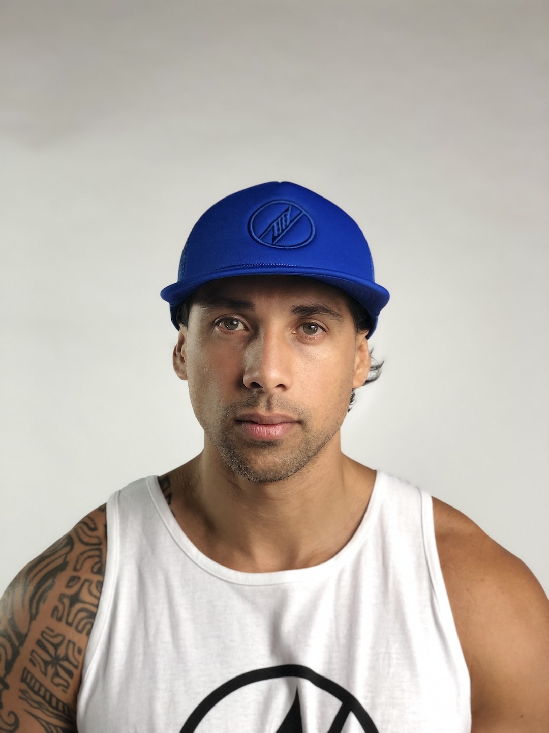 Male model wearing Logo Trucker Hat in Blue - Front View