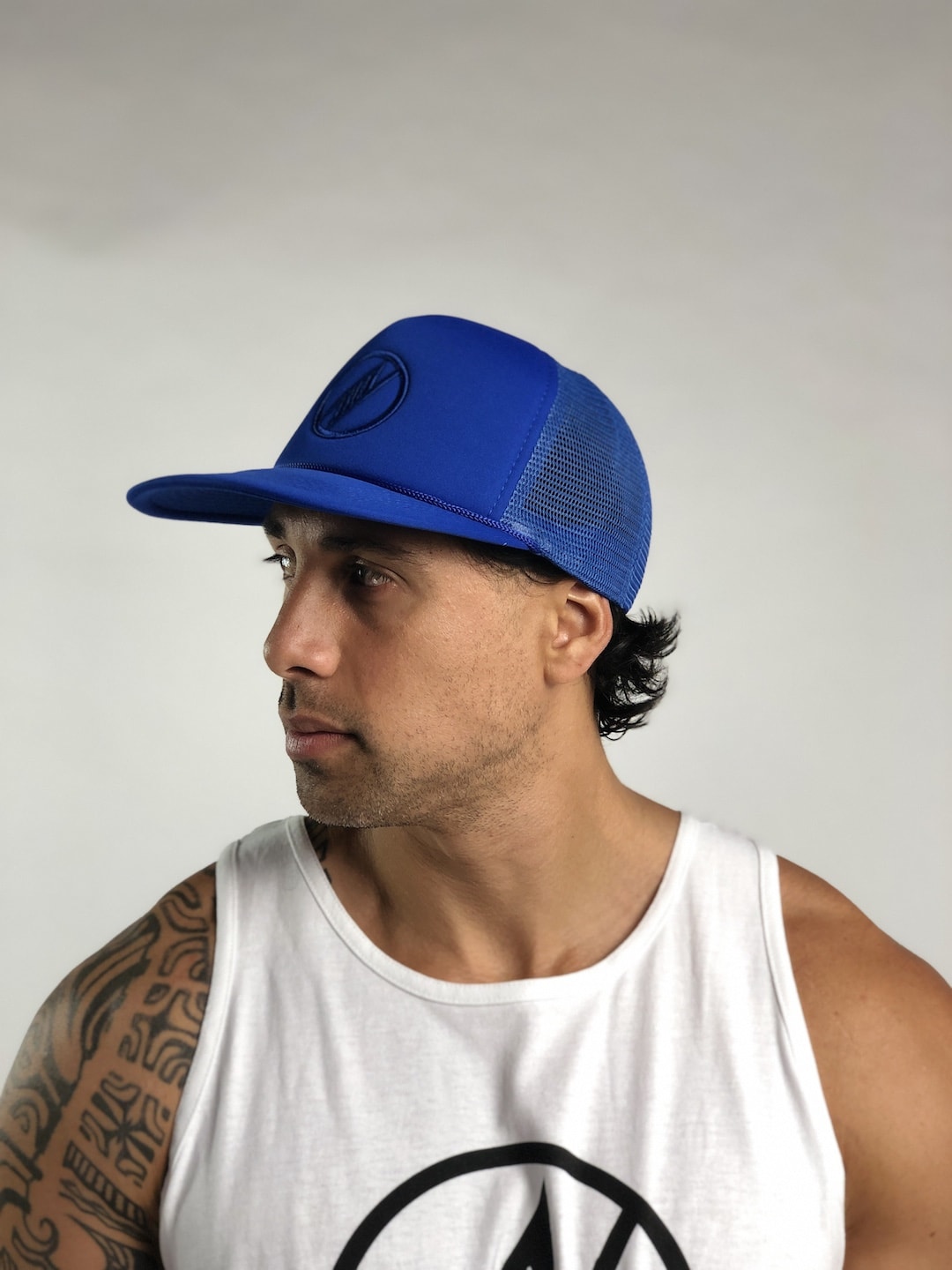 Male model wearing Logo Trucker Hat in Blue - Side View
