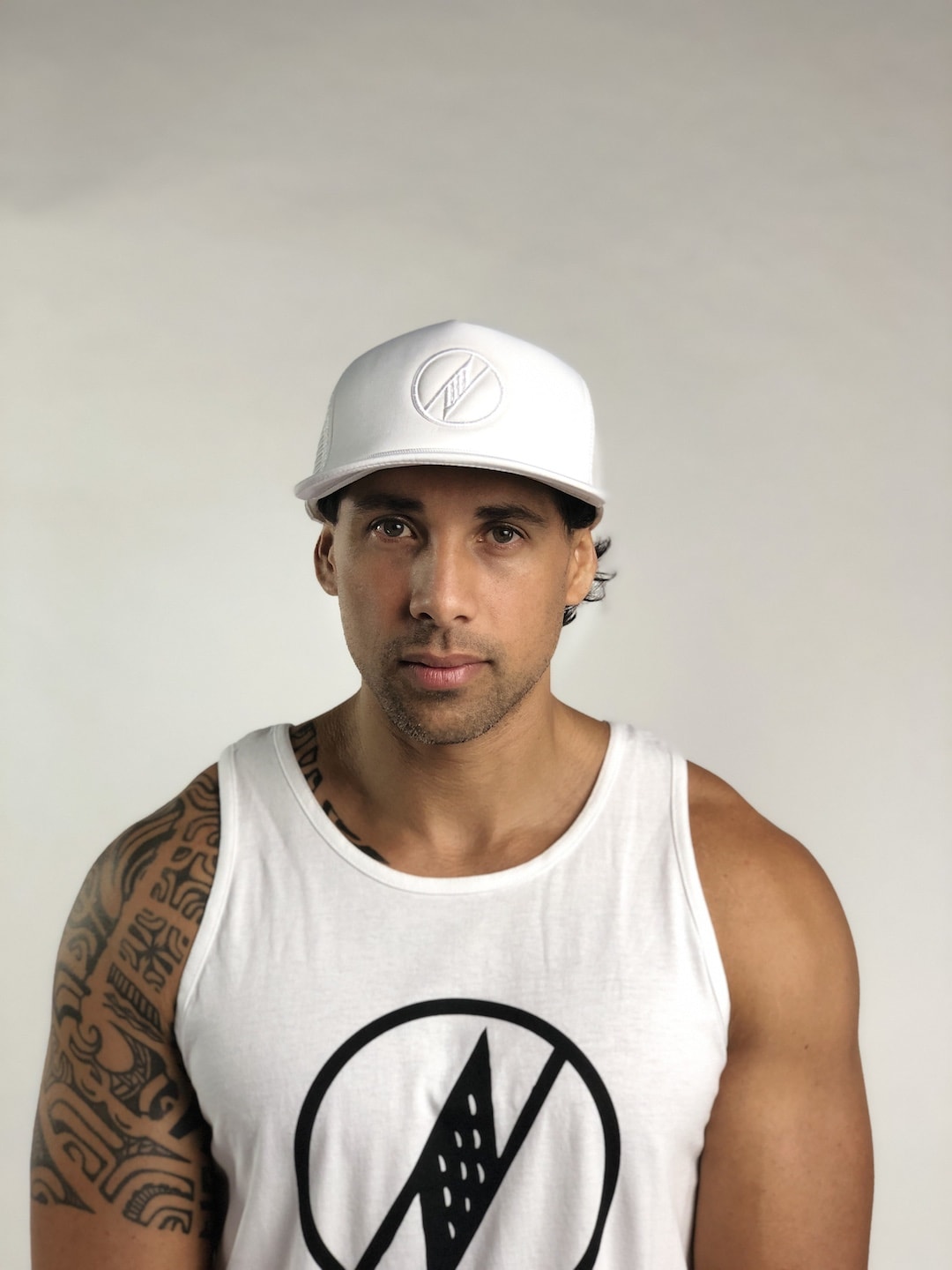 Male model wearing Logo Trucker Hat in White - Front View