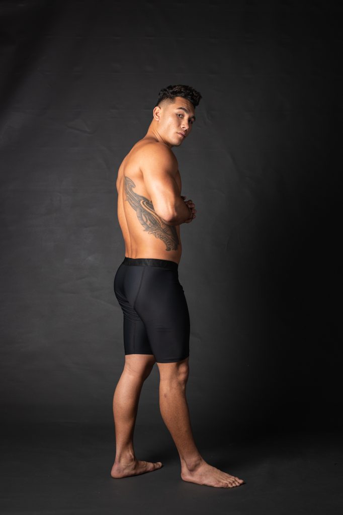 Male model wearing Uwila Midway Briefs in Black Solid Pattern - Back View