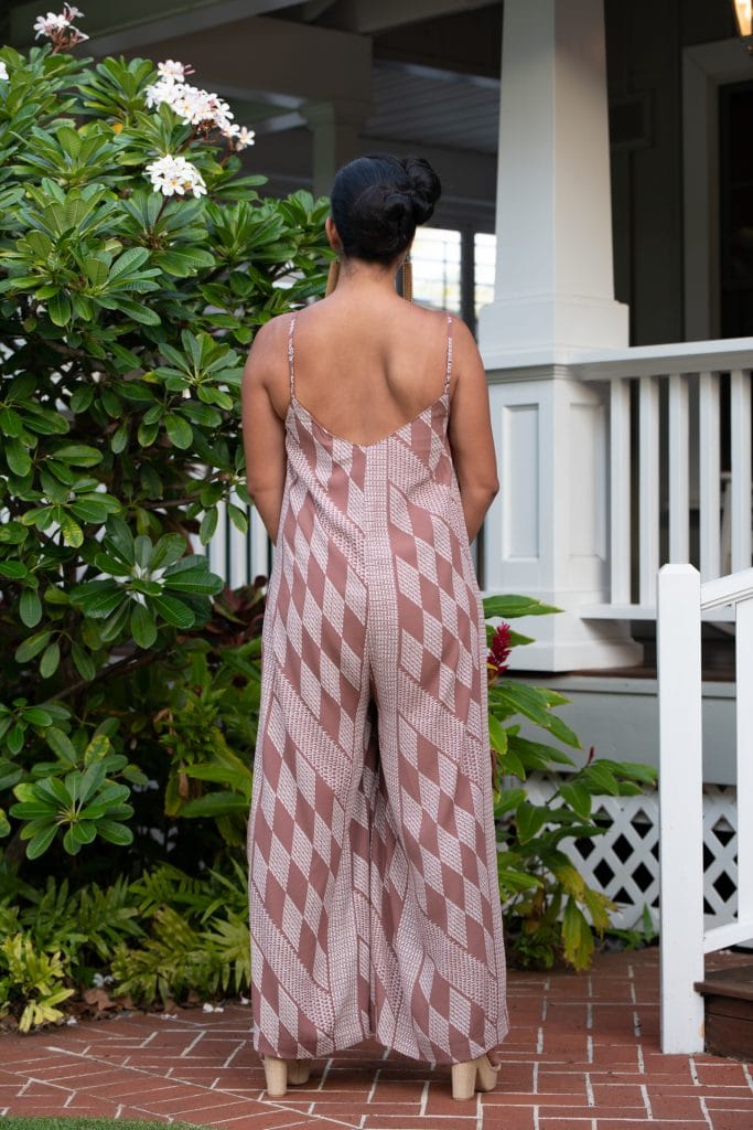 Model wearing Lanihau Jumpsuit in Fired Brick White Kamehameha Pattern - Back View