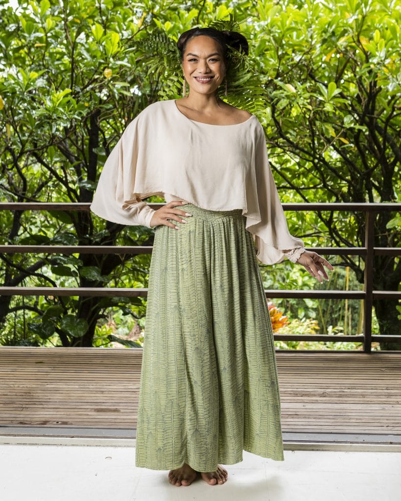 Female model wearing the Tapa Top in White and a skirt in sage green - Front View