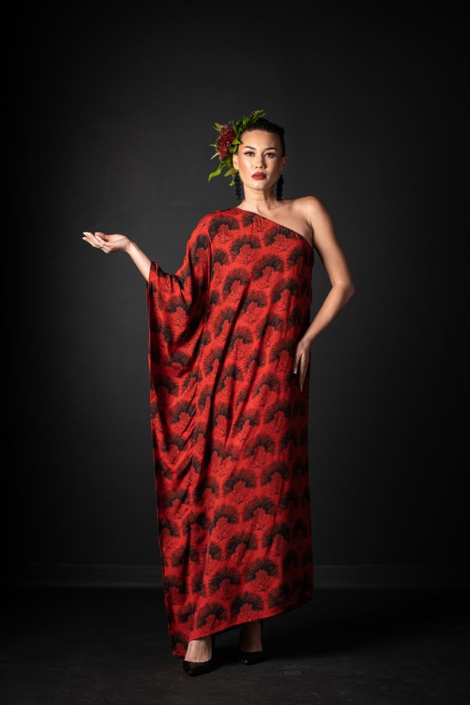Model wearing Malia Long Dress Long Sleeve in Firey Red-Black Kalihilehua Pattern- Back View
