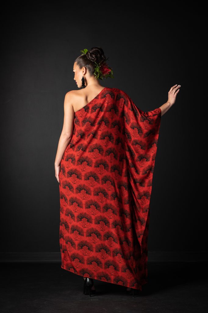 Model wearing Malia Long Dress Long Sleeve in Firey Red-Black Kalihilehua Pattern- Back View