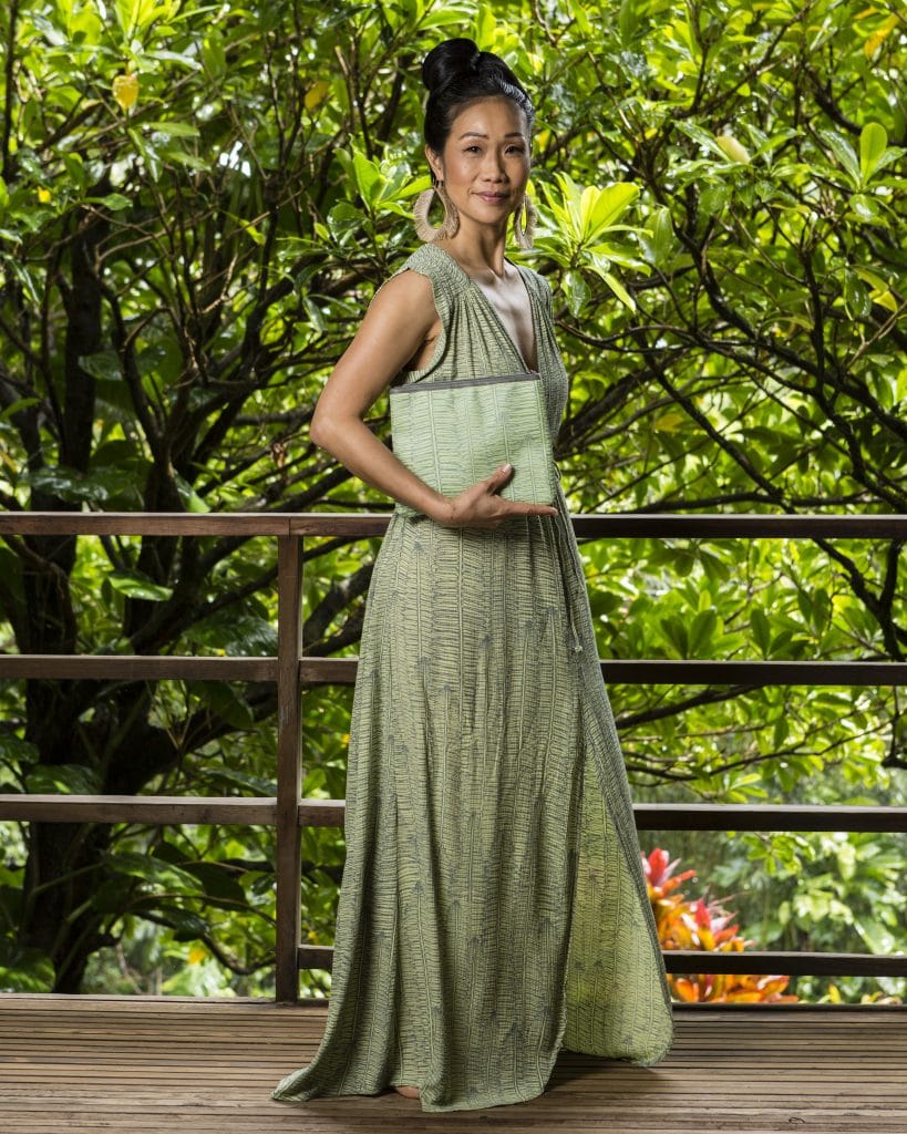 Model holding Flat Zip Pouch in Margarita Lily Pad Kupukupu pattern