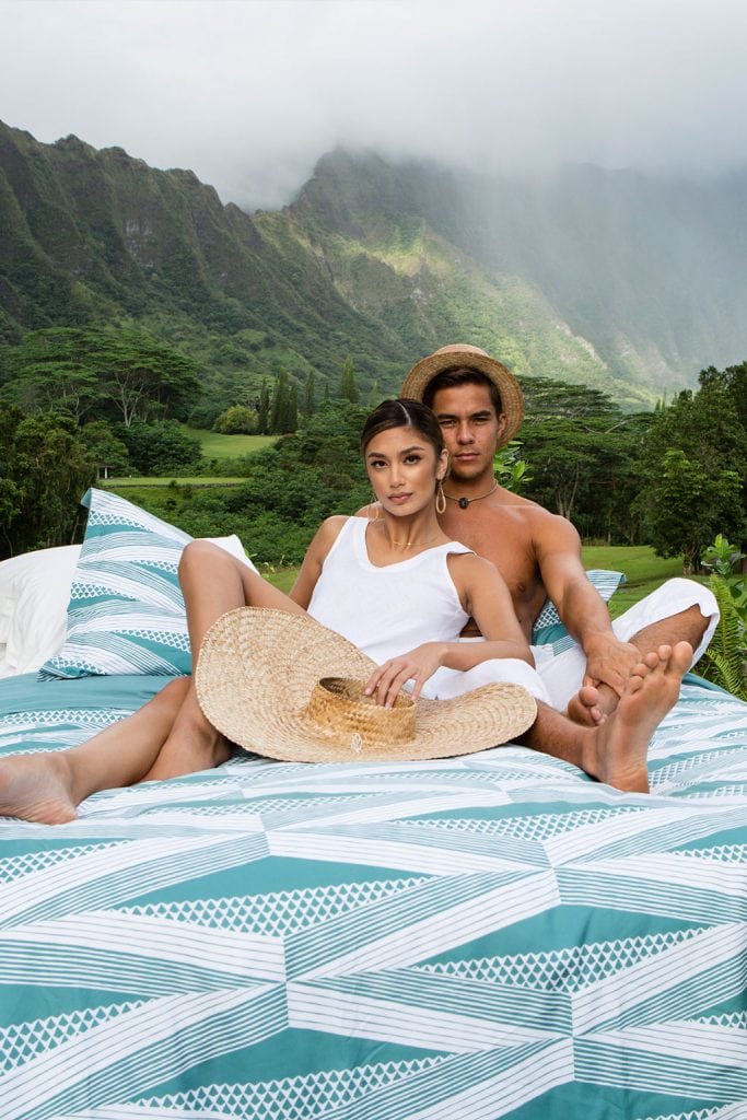 Male and Female Model sitting on Manaola Duvet Queen Set in Seafoam Kanaloa Pattern