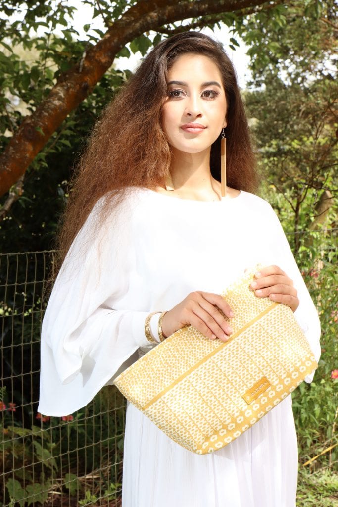 Female model holding Hapuna Clutch in Ako'Akoa'a Pattern in Rise Color