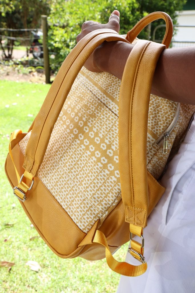 Male model wearing Huakai Backpack in Ako'Ako'a in Rise Color - Back View