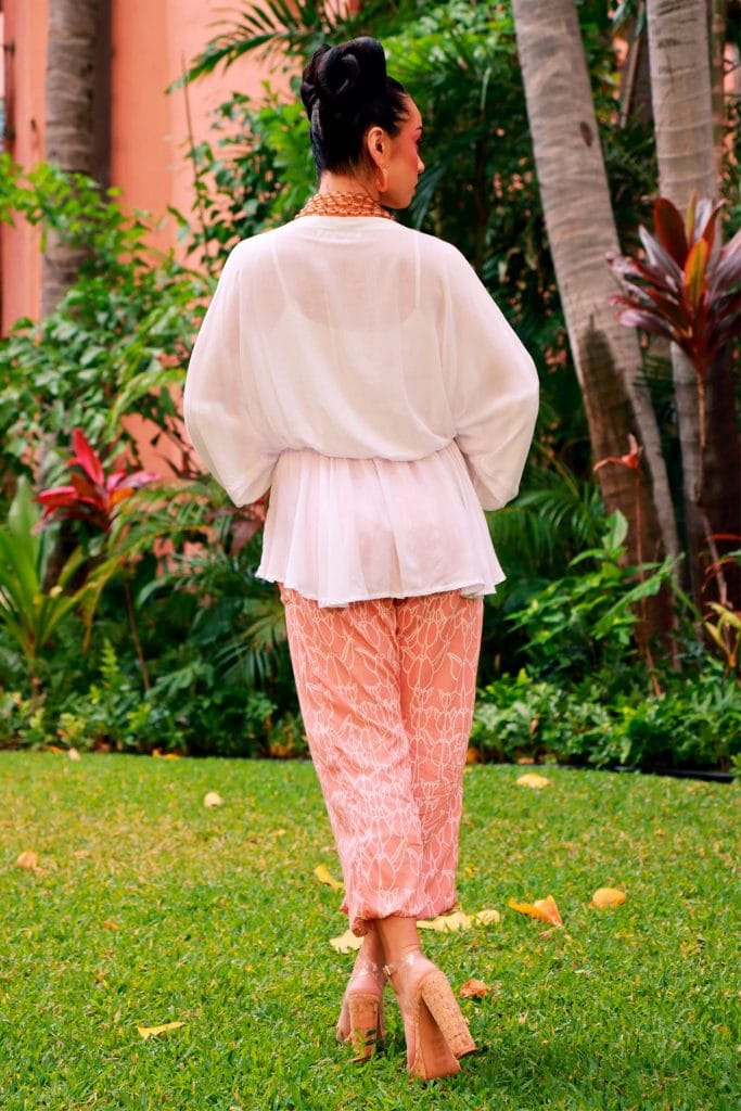 Female model wearing Nahele Pant in a Kapualiko Pattern and Lotus-Ash Rose Color - Back View