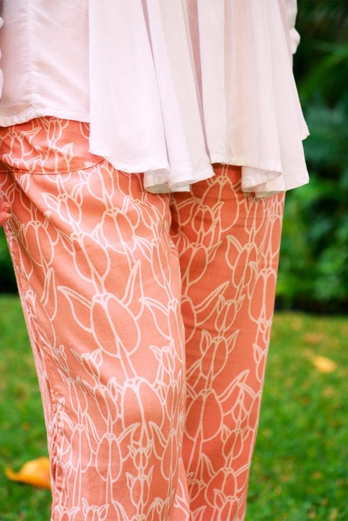 Female model wearing Nahele Pant in a Kapualiko Pattern and Lotus-Ash Rose Color - Close Up View