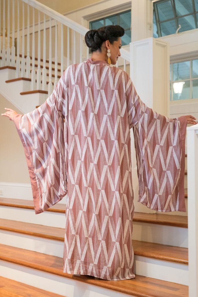 Female model wearing Kaliko Kaftan Long in Kanaloa Pattern and Fired Brick-White - Back View