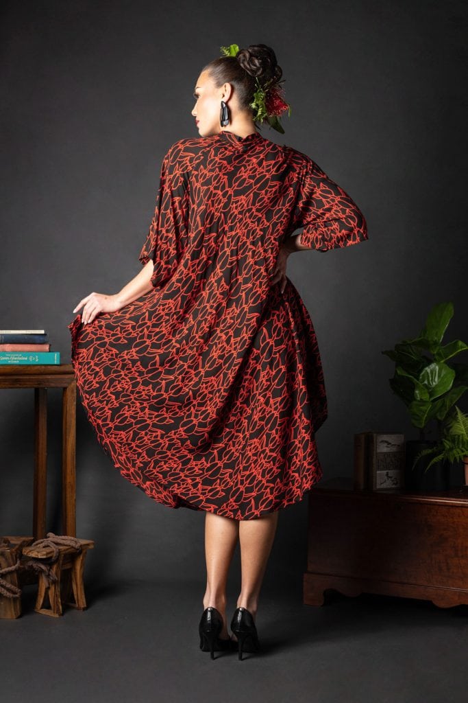 Female model wearing Koali Cut Dress in a Kapualiko Pattern in Black-Fiery Red - Back View