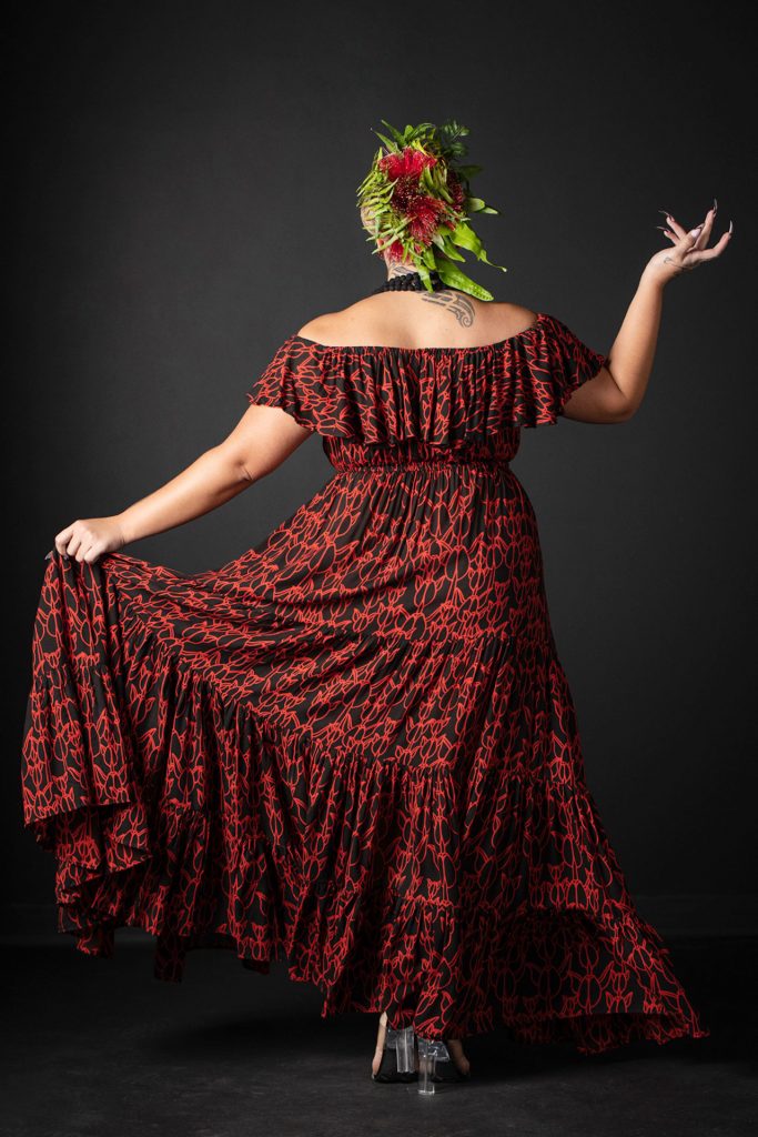 Female model wearing Lauae Maxi Dress in a Kapualiko Pattern in Black-Fiery Red - Back View