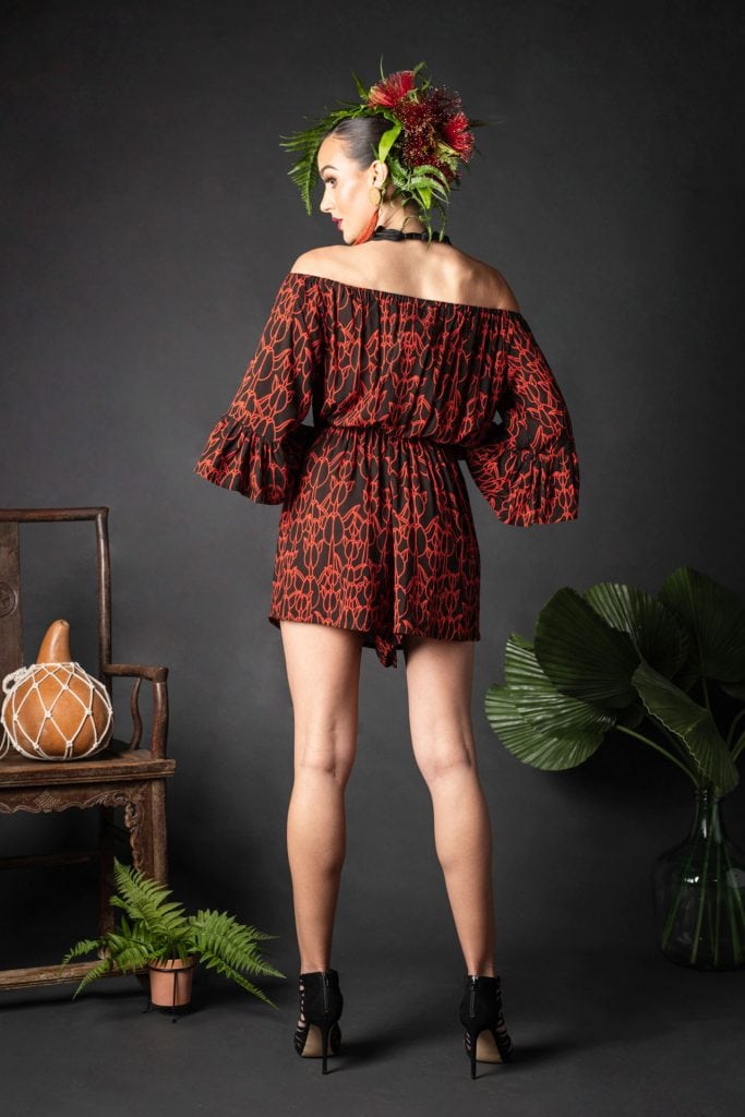 Female wearing a Manako Romper in Kapualiko Pattern and Black-Fiery Red - Back View