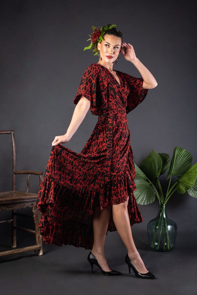 Female model wearing a Sepania Dress in Kapualiko Pattern and Black-Fiery Red - Side View
