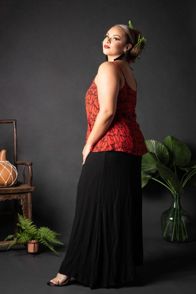 Female model wearing a Manaola Top 6 in a Kapualiko pattern and Fiery Red and Black Color - Side View