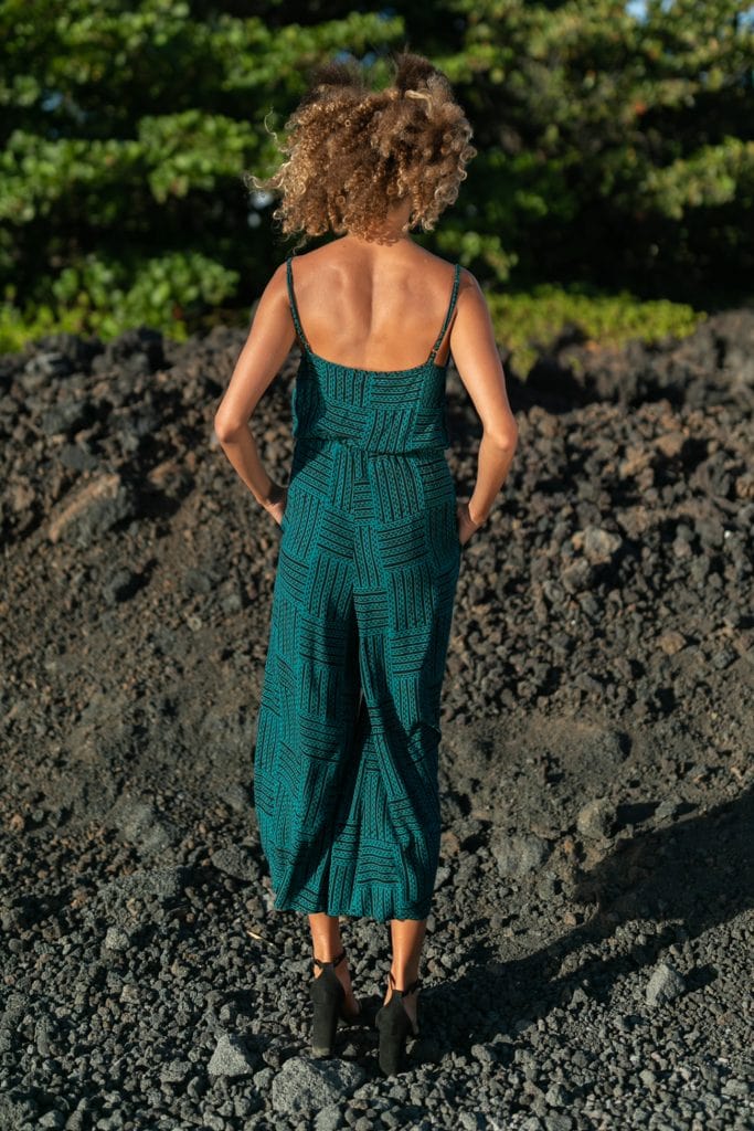 Female model wearing Leahi Jumpsuit in Black/Teal - Back View