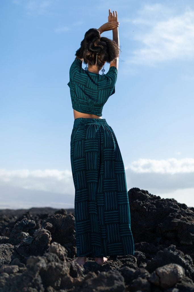 Female model wearing Manukea Top in Black/Teal - Back View