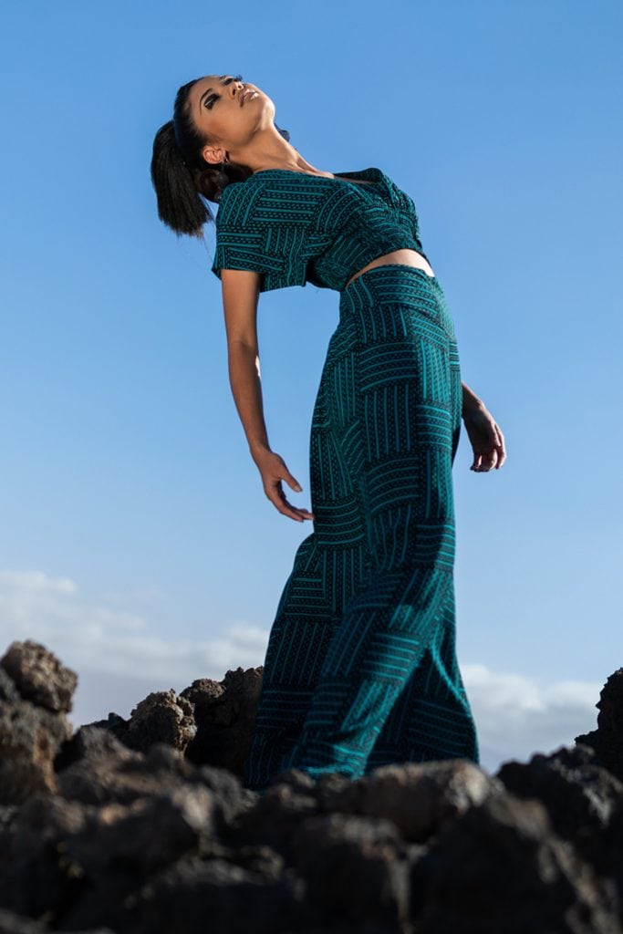 Female model wearing Manukea Top in Black/Teal - Side View