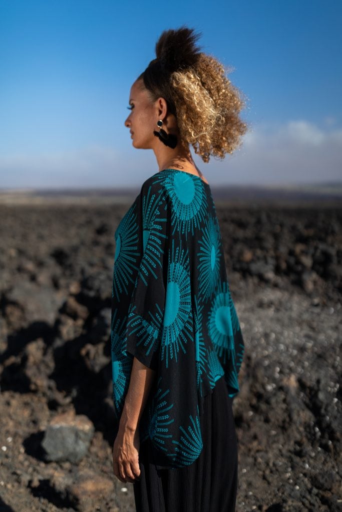 Female model wearing Puako Kaftan Shirt in in Dragonfly/Black Color and Kanehoalani Pattern - Side View