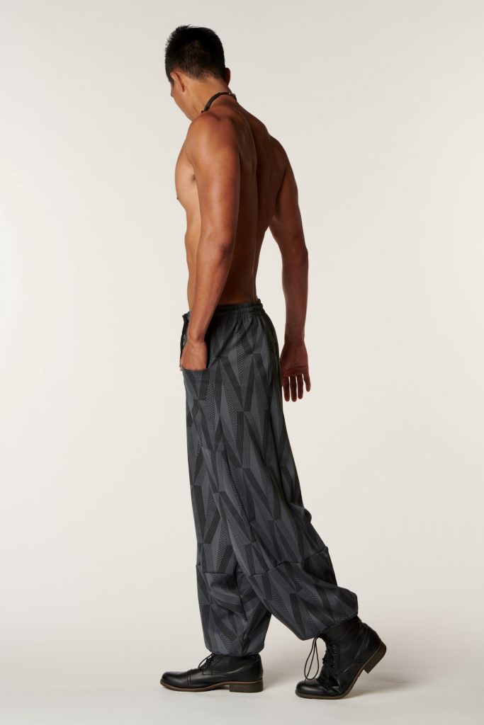 Male model wearing Waiola Pant in a Kanaola Print and Grey/Black Color - Side View