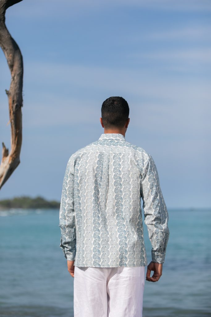 Male model wearing Aloha Long Sleeve in a Lei Kupee Print and Tofu/Real Teal Color - Back View