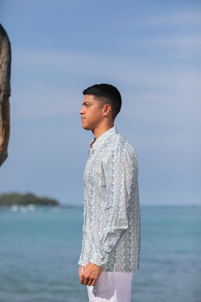 Male model wearing Aloha Long Sleeve in a Lei Kupee Print and Tofu/Real Teal Color - Side View