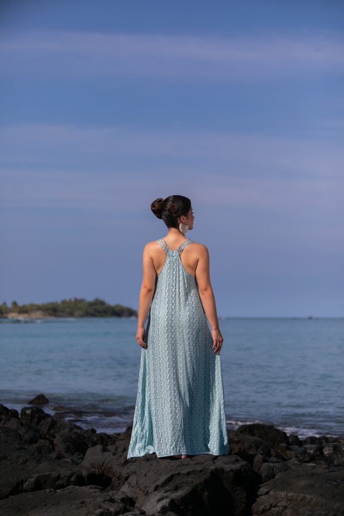 Female model wearing Kaimanahila Long Dress in a Lei Kupee Print and Blue Tint/Real Teal Color - Back View