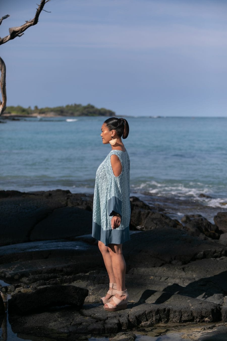 Female model wearing Kamakana Top w/ Pockets in a Lei Kupee Print and Blue Tint/Real Teal Color - Side View