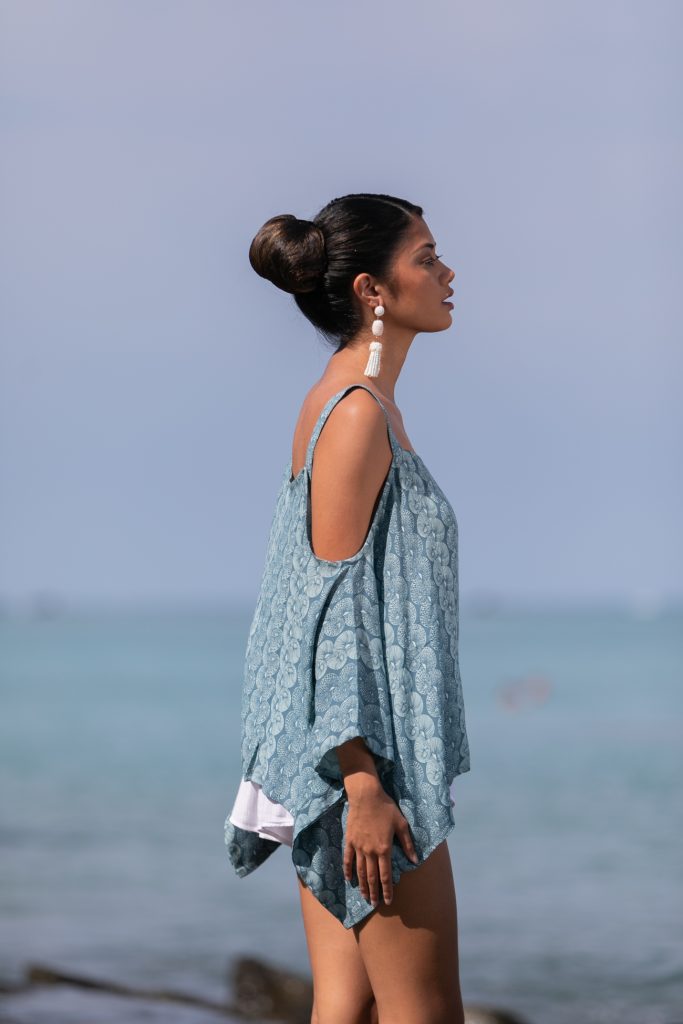Female model wearing a Konane in Lei Kupee Print and Real Teal/Blue Tint Color - Side View