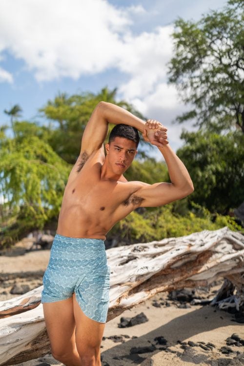 Male model wearing a pareo in Lei Kupee Pattern and a Blue Tint-Real Teal Color - Front View