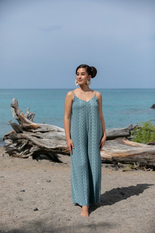 Female model wearing a Lanihau Jumpsuit in Lei Kupee Print and Real Teal/Blue Tint Color - Front View