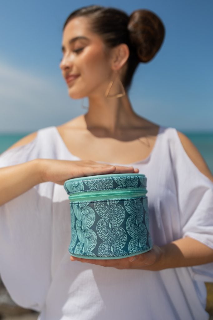 Female model holding a Lei Bag in a Lei Kupee Print and Blue Tint/Real Teal Color
