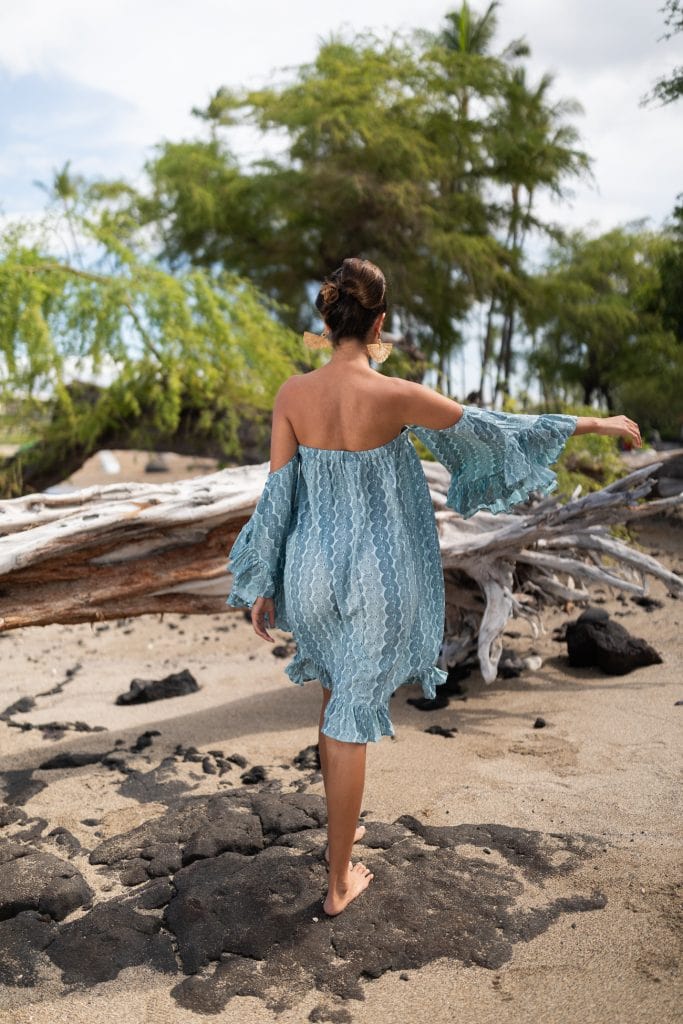 Female model wearing Leinani Dress in Lei Kupee Print and Blue Tint/Real Teal Color - Back View