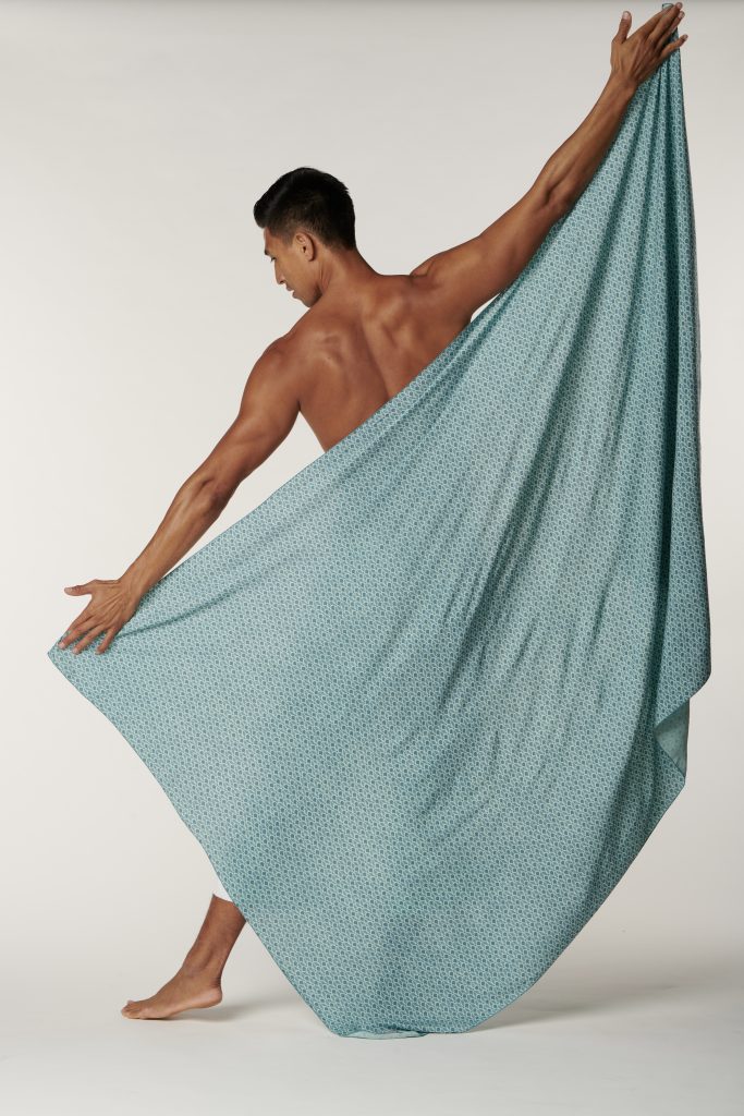 Male model wearing a pareo in Palulu Print and Real Teal/Blue Teal Color - Back View