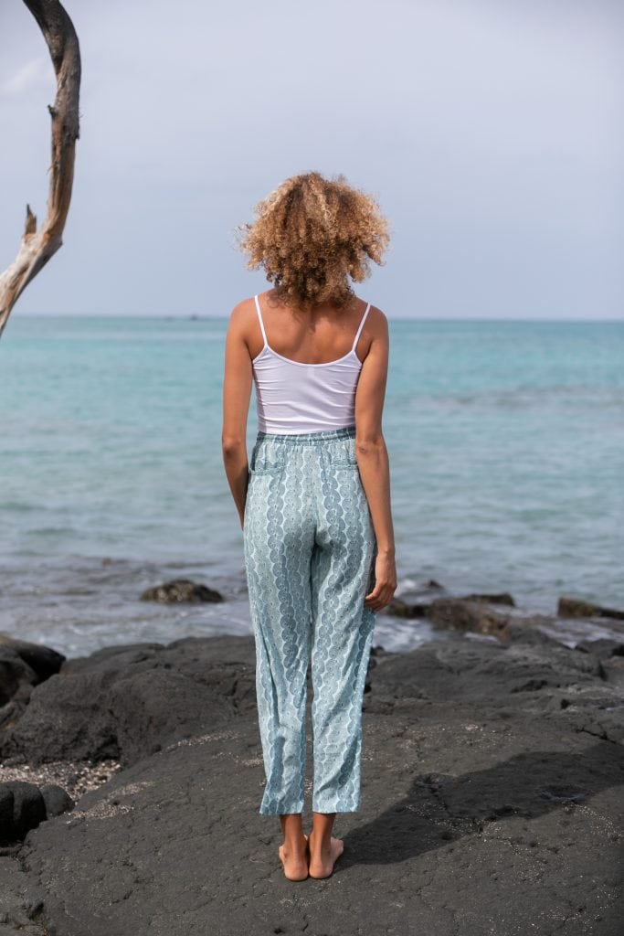 Female model wearing Uluhala Joggers in Lei Kupee Print and a Blue Tint/Real Tint Color - Back View
