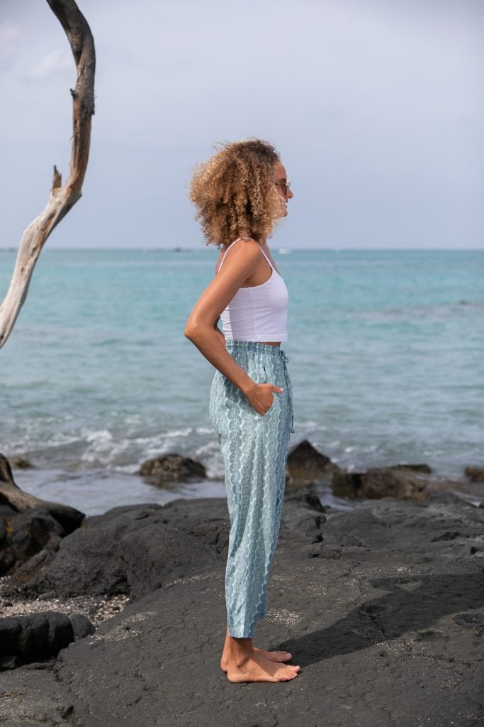 Female model wearing Uluhala Joggers in Lei Kupee Print and a Blue Tint/Real Tint Color - Side View