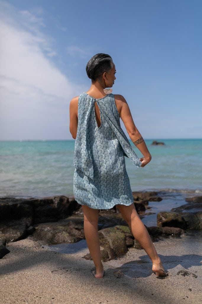 Female model wearing Waiulu Top in Lei Kupee Print and Real Teal/Blue Teal Color - Back View